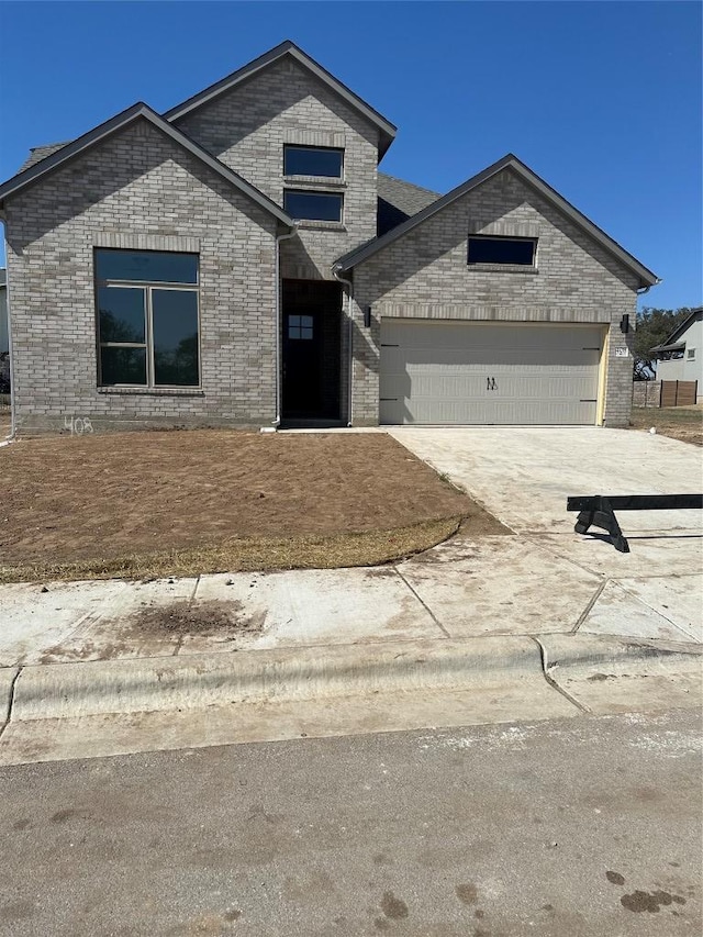 view of front of property with brick siding, driveway, and an attached garage