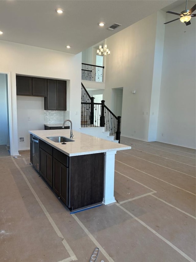 kitchen with recessed lighting, a sink, a towering ceiling, visible vents, and tasteful backsplash