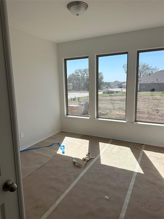 spare room featuring plenty of natural light and baseboards