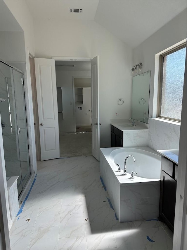 full bath with lofted ceiling, vanity, a shower stall, and visible vents