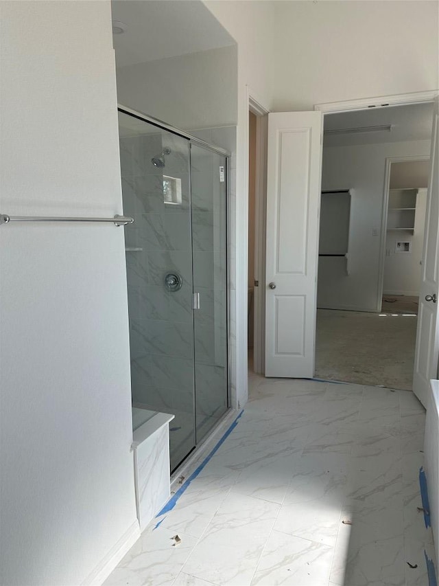 full bath featuring marble finish floor and a marble finish shower