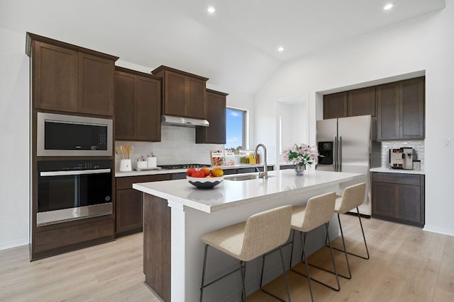408 Ridgewell Loop, Georgetown, TX 78633 - kitchen with stainless steel appliances, tasteful backsplash, a kitchen island with sink, light wood finished floors, and recessed lighting