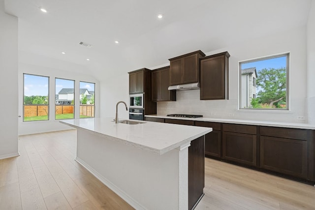 408 Ridgewell Loop, Georgetown, TX 78633 - kitchen featuring gas cooktop, under cabinet range hood, decorative backsplash, plenty of natural light, and lofted ceiling