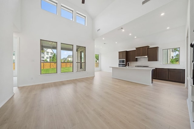 408 Ridgewell Loop, Georgetown, TX 78633 - unfurnished living room with ceiling fan, a high ceiling, and light wood-type flooring