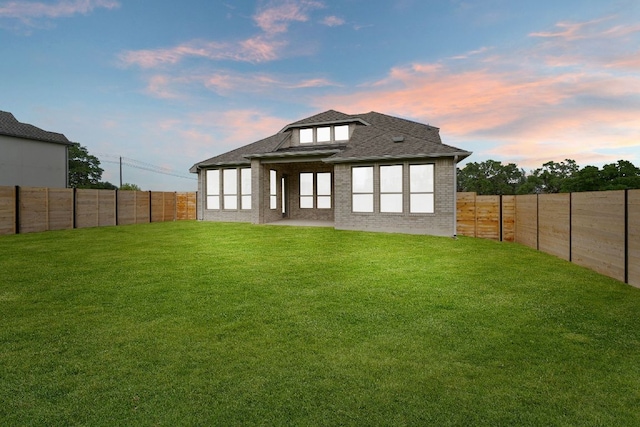 408 Ridgewell Loop, Georgetown, TX 78633 - back of property at dusk featuring a fenced backyard, brick siding, and a shingled roof