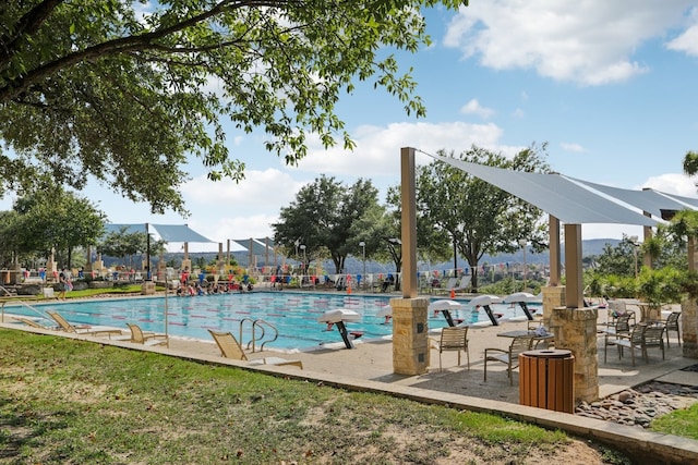 view of swimming pool featuring a yard and a patio