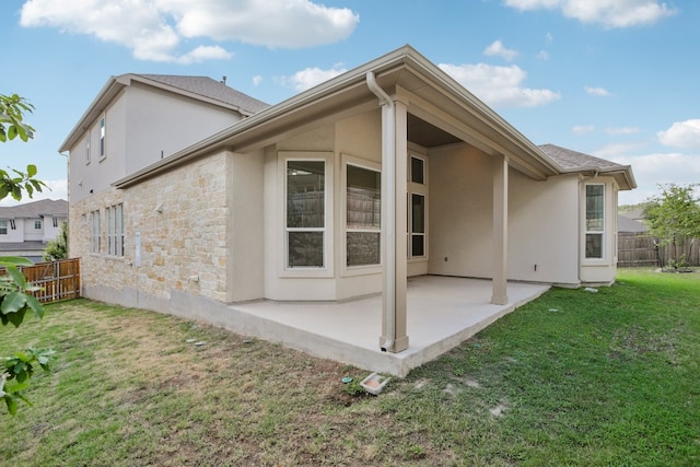 rear view of property with a lawn and a patio area