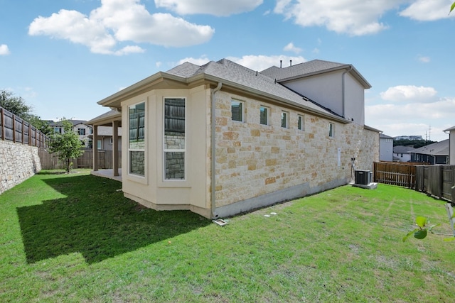 back of property with a lawn and central air condition unit