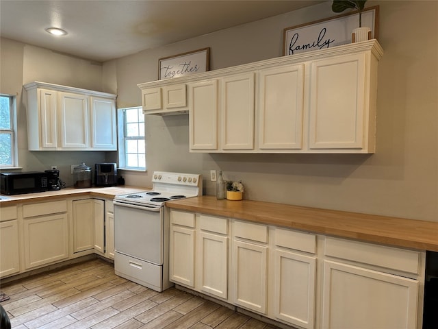 kitchen with white electric range oven, light wood-type flooring, and butcher block counters