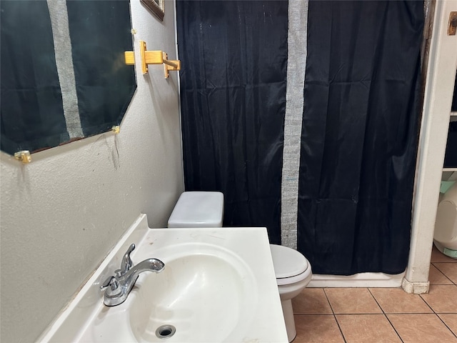 bathroom featuring toilet, a shower with shower curtain, sink, and tile patterned floors