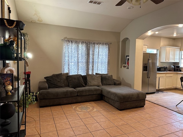 tiled living room with lofted ceiling and ceiling fan