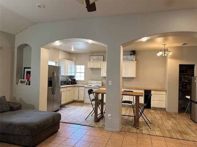 kitchen featuring stainless steel fridge, light hardwood / wood-style floors, white cabinets, white electric stove, and decorative light fixtures