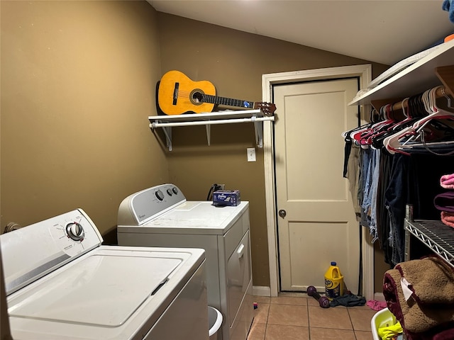 clothes washing area with washer and clothes dryer and light tile patterned floors