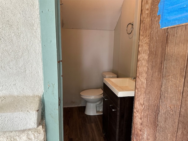 bathroom with hardwood / wood-style flooring, vanity, and toilet