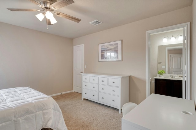 bedroom featuring light carpet, ensuite bathroom, sink, and ceiling fan