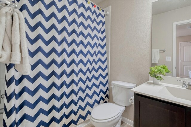 bathroom featuring toilet, curtained shower, and vanity