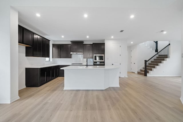 537 Raleigh Dr, Georgetown, TX 78633 - kitchen with stainless steel microwave, wall oven, light wood-style floors, light countertops, and recessed lighting