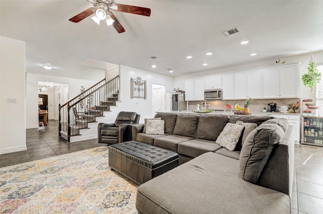 living room featuring ceiling fan, dark tile patterned floors, and wine cooler