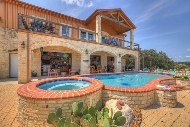 view of swimming pool with an in ground hot tub and a patio area