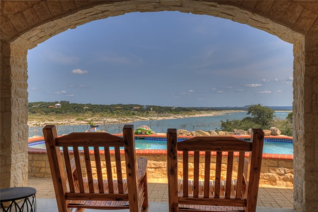 view of patio with a water view and a pool