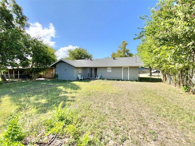 rear view of property featuring a yard