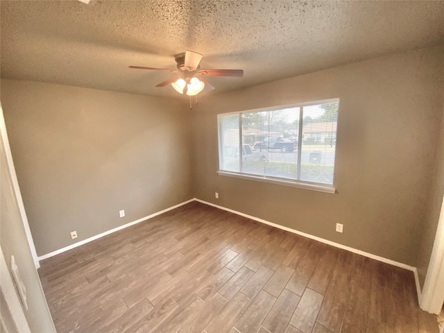 unfurnished room with ceiling fan, hardwood / wood-style floors, and a textured ceiling