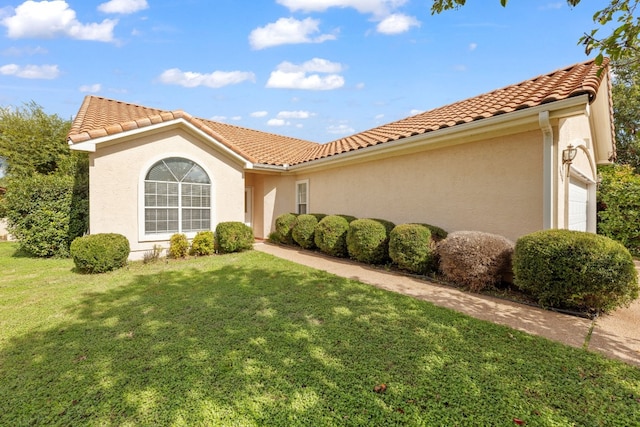 mediterranean / spanish home with a front lawn