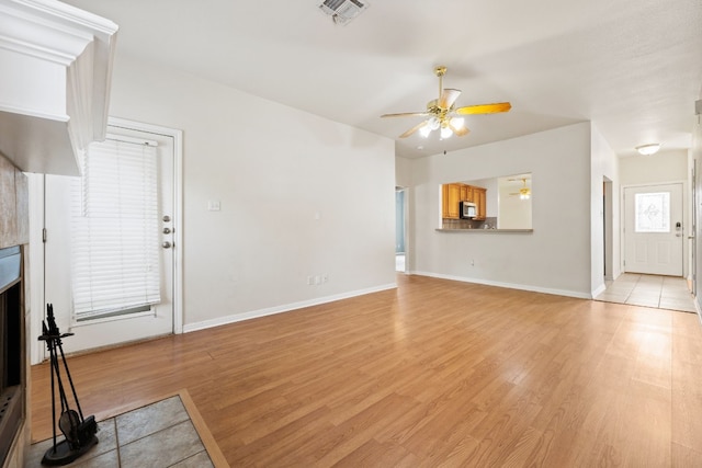 unfurnished living room with light hardwood / wood-style flooring and ceiling fan