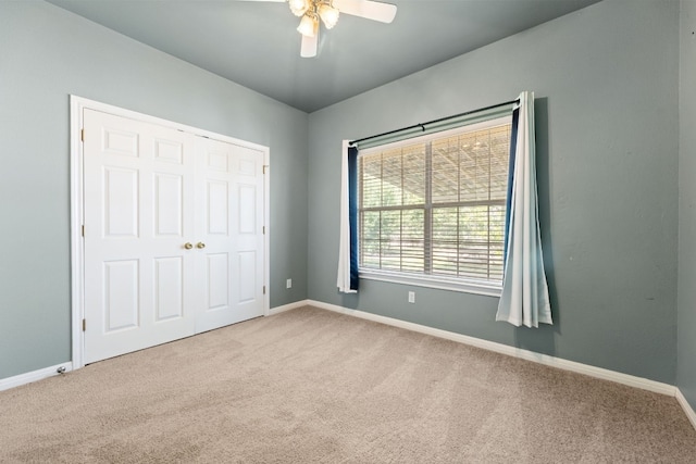 unfurnished bedroom featuring ceiling fan, light colored carpet, and a closet