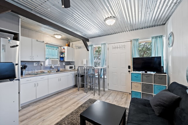 interior space with ceiling fan, light hardwood / wood-style flooring, sink, and a healthy amount of sunlight