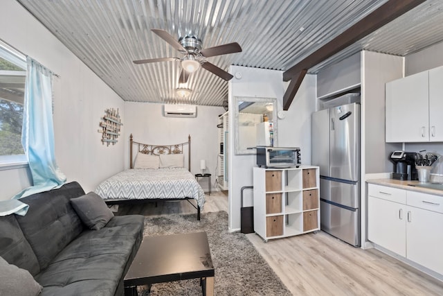 bedroom with ceiling fan, light hardwood / wood-style floors, stainless steel fridge, and a wall mounted air conditioner