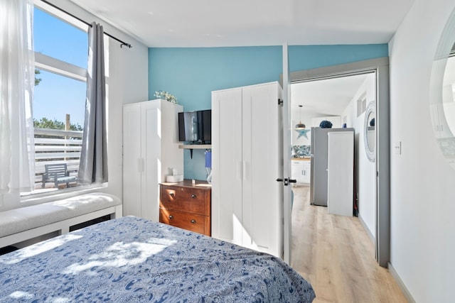 bedroom with vaulted ceiling and light hardwood / wood-style floors