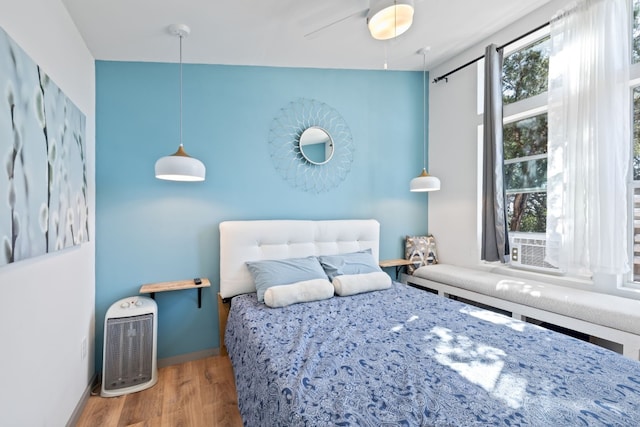 bedroom featuring wood-type flooring, lofted ceiling, multiple windows, and ceiling fan