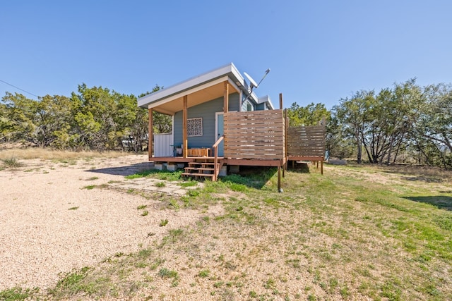 rear view of house with a deck and a lawn