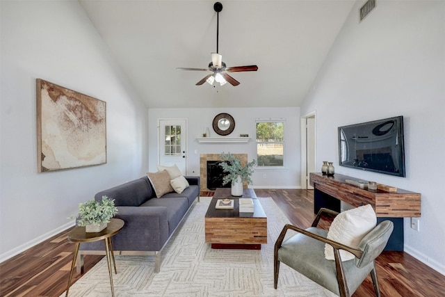 living room with ceiling fan, wood-type flooring, and high vaulted ceiling