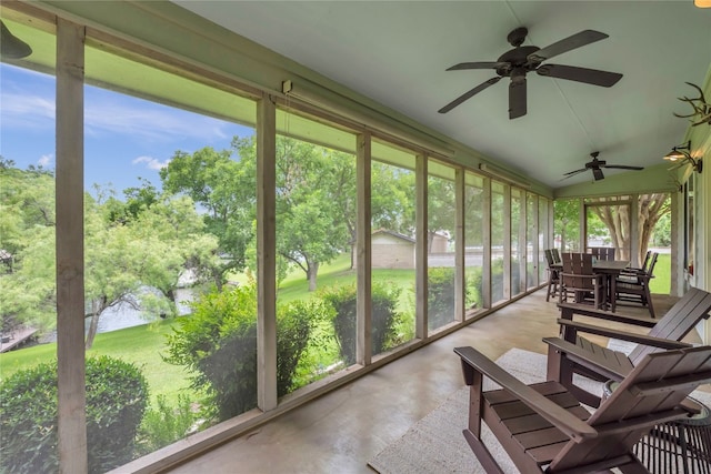 sunroom featuring ceiling fan, vaulted ceiling, and a healthy amount of sunlight