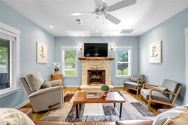 living room featuring a fireplace, hardwood / wood-style floors, and ceiling fan