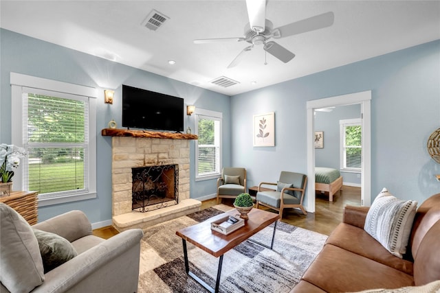 living room featuring a fireplace, hardwood / wood-style floors, and ceiling fan