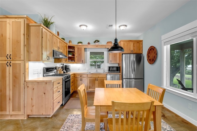 kitchen featuring light brown cabinets, appliances with stainless steel finishes, hanging light fixtures, and sink