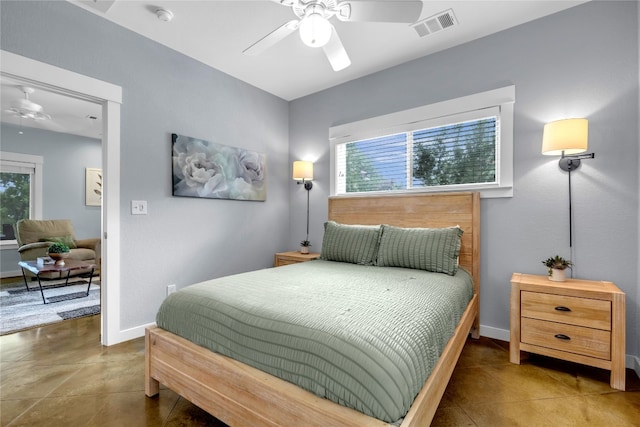 tiled bedroom featuring ceiling fan and multiple windows