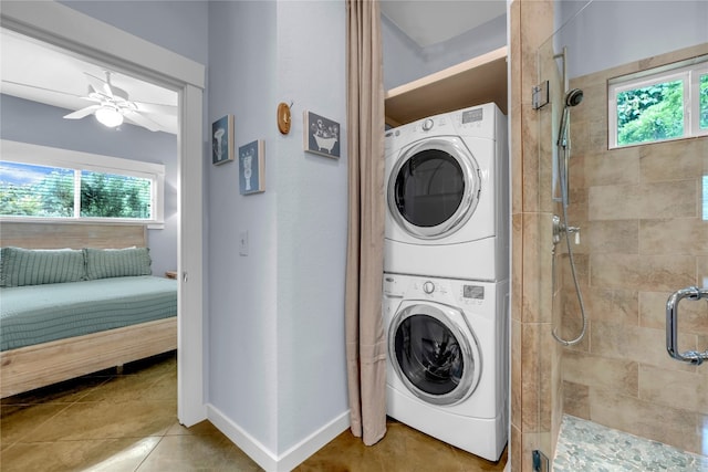 laundry area with ceiling fan, tile patterned flooring, and stacked washer and dryer