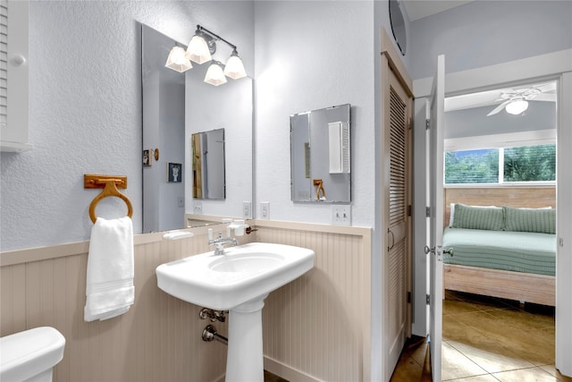 bathroom with ceiling fan, tile patterned flooring, and toilet