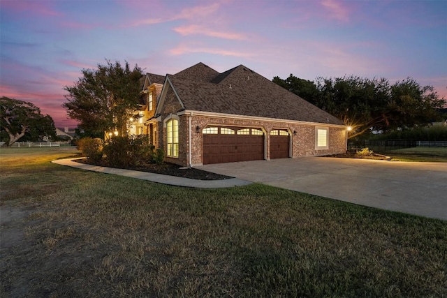 view of front of property featuring an attached garage, brick siding, fence, concrete driveway, and a lawn