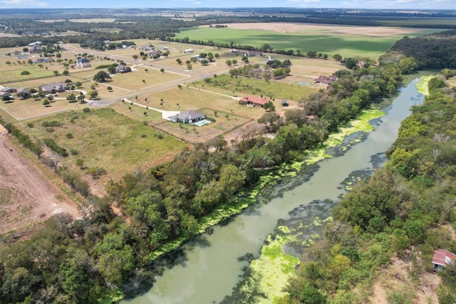 birds eye view of property featuring a water view and a rural view