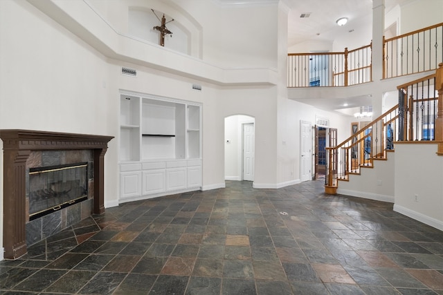 interior space featuring a notable chandelier, a high ceiling, and a fireplace