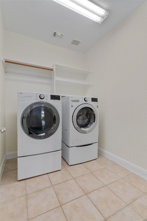 laundry room featuring light tile patterned floors and washing machine and dryer