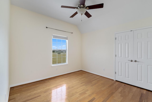 unfurnished bedroom with vaulted ceiling, ceiling fan, a closet, and light hardwood / wood-style flooring