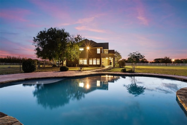 pool at dusk featuring fence and a fenced in pool