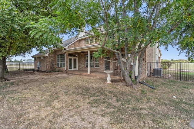 view of front of property featuring a ceiling fan, french doors, brick siding, and fence