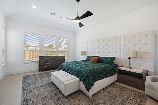 bedroom featuring hardwood / wood-style floors, vaulted ceiling, and ceiling fan